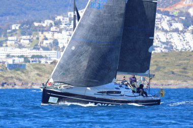 Bodrum, Hindi. 16 Mart 2024: Yelkenliler Ege Denizi 'nin mavi sularında, ünlü tatil beldesi Bodrum' un kıyılarında rüzgarlı havada yelken açıyorlar..