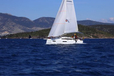 Bodrum, Hindi. 16 Mart 2024: Yelkenliler Ege Denizi 'nin mavi sularında, ünlü tatil beldesi Bodrum' un kıyılarında rüzgarlı havada yelken açıyorlar..