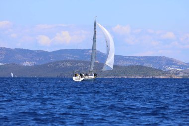 Bodrum, Hindi. 16 Mart 2024: Yelkenliler Ege Denizi 'nin mavi sularında, ünlü tatil beldesi Bodrum' un kıyılarında rüzgarlı havada yelken açıyorlar..