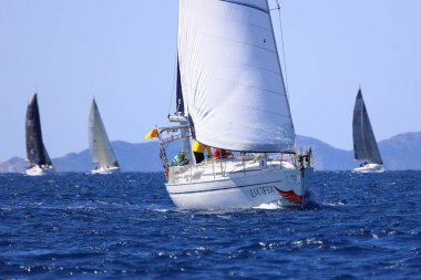 Bodrum, Hindi. 16 Mart 2024: Yelkenliler Ege Denizi 'nin mavi sularında, ünlü tatil beldesi Bodrum' un kıyılarında rüzgarlı havada yelken açıyorlar..