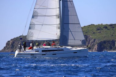 Bodrum, Hindi. 16 Mart 2024: Yelkenliler Ege Denizi 'nin mavi sularında, ünlü tatil beldesi Bodrum' un kıyılarında rüzgarlı havada yelken açıyorlar..