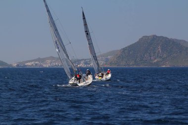 Bodrum, Hindi. 22 Mart 2019: Yelkenliler Ege Denizi 'nin mavi sularında, ünlü tatil beldesi Bodrum' un kıyılarında rüzgarlı havada yelken açıyorlar..