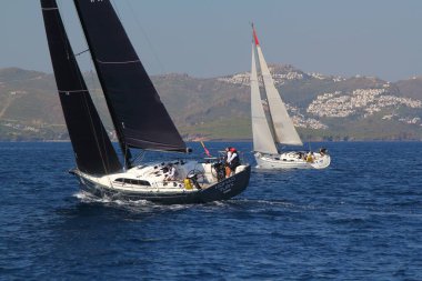 Bodrum, Hindi. 22 Mart 2019: Yelkenliler Ege Denizi 'nin mavi sularında, ünlü tatil beldesi Bodrum' un kıyılarında rüzgarlı havada yelken açıyorlar..