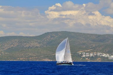 Bodrum, Hindi. 24 Mayıs 2019: Ege Denizi 'nin mavi sularında, ünlü tatil beldesi Bodrum' un kıyılarında yelkenliler rüzgarlı havada yelken açıyor.