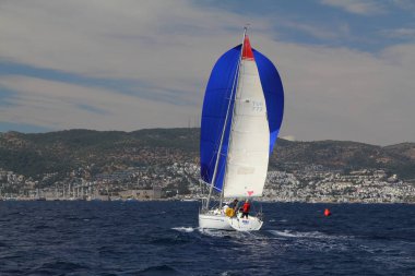 Bodrum, Hindi. 24 Mayıs 2019: Ege Denizi 'nin mavi sularında, ünlü tatil beldesi Bodrum' un kıyılarında yelkenliler rüzgarlı havada yelken açıyor.