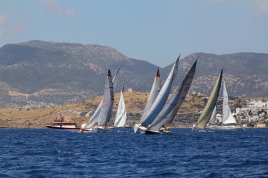 Bodrum, Hindi. 24 Mayıs 2019: Ege Denizi 'nin mavi sularında, ünlü tatil beldesi Bodrum' un kıyılarında yelkenliler rüzgarlı havada yelken açıyor.