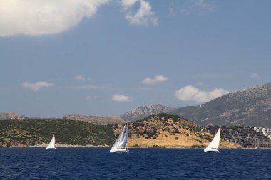 Bodrum, Hindi. 24 Mayıs 2019: Ege Denizi 'nin mavi sularında, ünlü tatil beldesi Bodrum' un kıyılarında yelkenliler rüzgarlı havada yelken açıyor.