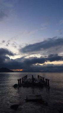 Eski terk edilmiş ahşap balıkçı iskelesi kırsal bölgedeki denizde. Sosyal medya için dikey video.