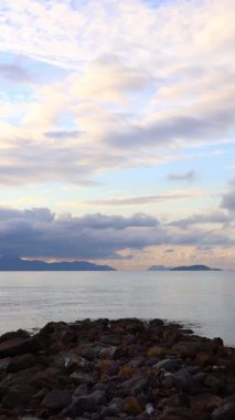 Deniz kenti Turgutreis ve muhteşem gün batımları. Bodrum, Hindi. Ege Denizi 'nin ortasında büyük bir kaya. sosyal medya için dikey video.