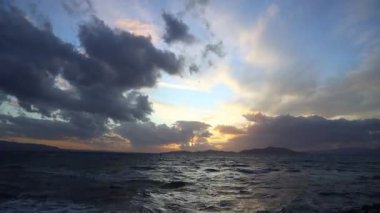 Sonbaharda Ege Denizi üzerinde bulutlu bir günde muhteşem bir gün batımı..