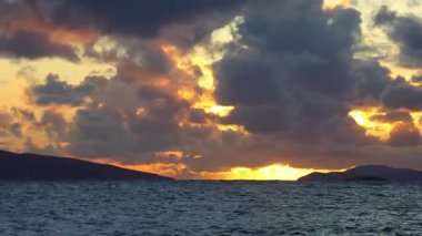 Sonbaharda Ege Denizi üzerinde bulutlu bir günde muhteşem bir gün batımı..