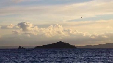 Sonbaharda Ege Denizi üzerinde bulutlu bir günde muhteşem bir gün batımı..