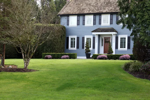 Элегантный особняк с большой лужайкой перед домом — стоковое фото