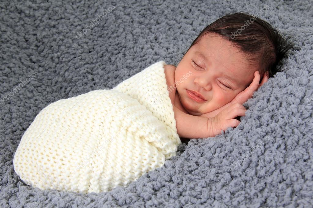 Newborn girl on grey blanket