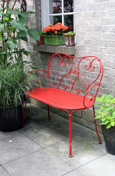 Red bench outside on a patio — Stockfoto