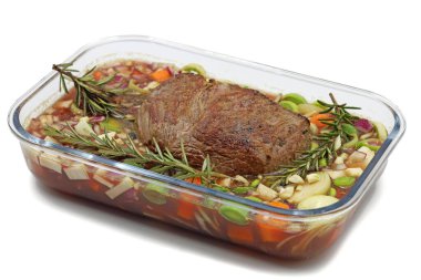 Biberiyeli biftek ve beyaz arka planda izole edilmiş cam kasede sebze.