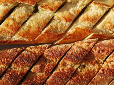 Sarımsaklı baget ekmeği ve güneş ışığında aromatik otlar. Ekmeğin makro yemek fotoğrafı.