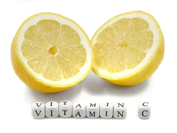 Fresh sliced ripe lemon with VITAMIN C word made from mini letter cubes isolated on white background — ストック写真