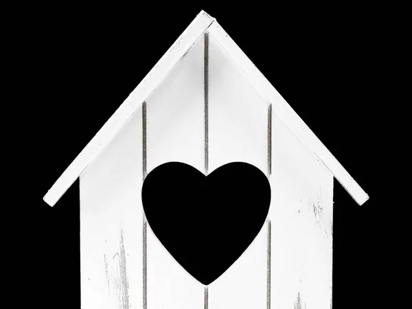 Vista frontal de la casa de madera miniatur con forma de corazón en el interior aislado sobre fondo negro, concepto de hogar dulce con espacio de copia — Foto de Stock