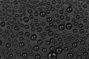 Siyah arkaplan dokusuna su damlaları. Su damlalarıyla kaplı koyu renk bir arka plan camı. Sudaki gri kabarcıklar