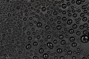 Siyah arkaplan dokusuna su damlaları. Su damlalarıyla kaplı koyu renk bir arka plan camı. Sudaki gri kabarcıklar