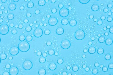 Mavi arkaplan dokusuna su damlaları. Arkaplan camı su damlalarıyla kaplı. Sudaki kabarcıklar