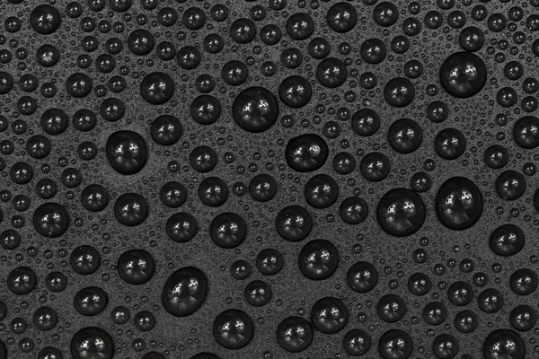 Water drops on black background texture. Dark backdrop glass covered with drops of water. gray bubbles in water