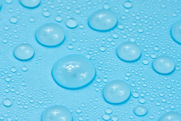 Water drops on blue background texture. Backdrop glass covered with drops of water. bubbles in water