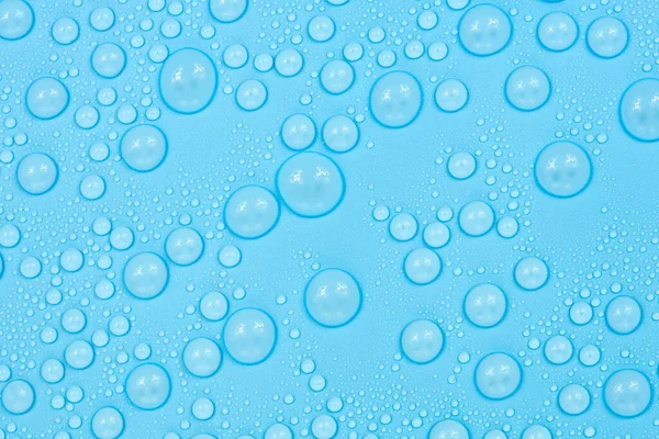 Water drops on blue background texture. Backdrop glass covered with drops of water. bubbles in water