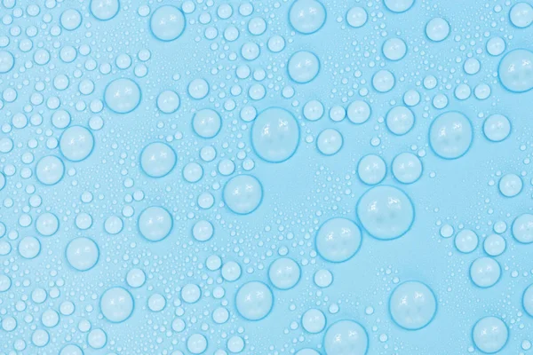 Mavi arkaplan dokusuna su damlaları. Arkaplan camı su damlalarıyla kaplı. Sudaki kabarcıklar
