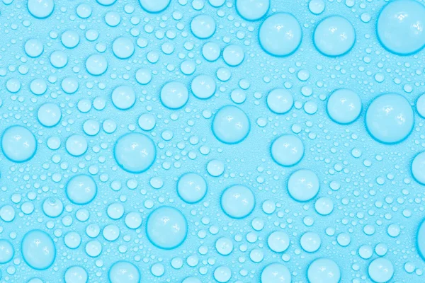 Mavi arkaplan dokusuna su damlaları. Arkaplan camı su damlalarıyla kaplı. Sudaki kabarcıklar