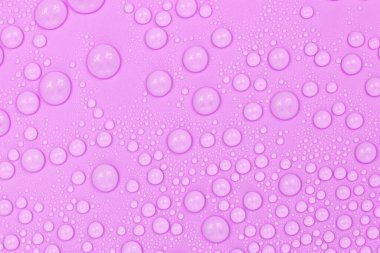 Mor arkaplan dokusuna su damlaları. Arkaplan camı su damlalarıyla kaplı. Suda mor kabarcıklar