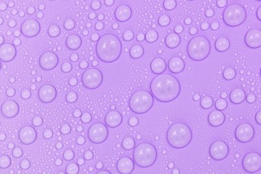 Mor arkaplan dokusuna su damlaları. Arkaplan camı su damlalarıyla kaplı. Suda mor kabarcıklar