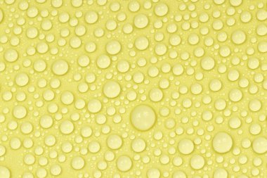 Sarı arkaplan dokusuna su damlaları. Arkaplan camı su damlalarıyla kaplı. Suda sarı kabarcıklar. bira dokusu
