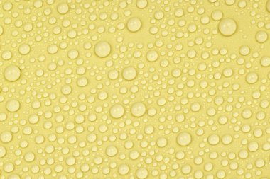 Sarı arkaplan dokusuna su damlaları. Arkaplan camı su damlalarıyla kaplı. Suda sarı kabarcıklar. bira dokusu