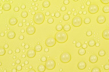Sarı arkaplan dokusuna su damlaları. Arkaplan camı su damlalarıyla kaplı. Suda sarı kabarcıklar. bira dokusu