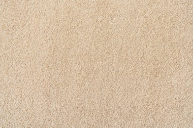 Bej rengi kıvırcık yün, dikişsiz doku arka planı. kısa fabrika malzemesi ile doku.