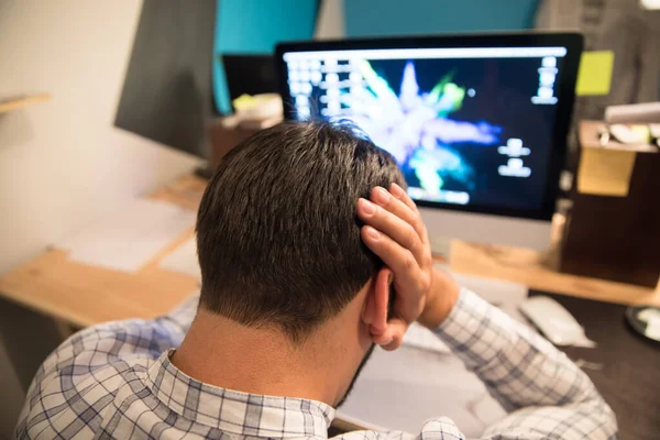 sad business man hand in head with working tabl