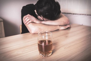 Üzgün adam ve masada bir bardak bira