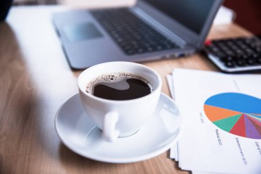 Tablo üzerinde bilgisayar olan grafik ve kahve kağıdı