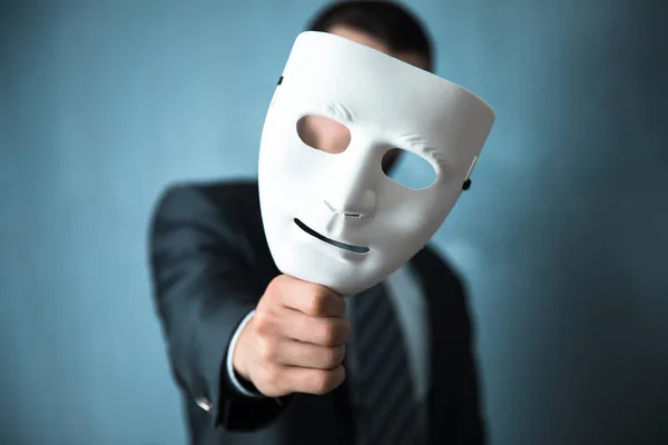 Siyah duvarda beyaz maskeli bir adam.