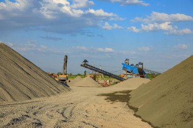 Güneşli bir günde endüstriyel makineyle çakıl ocağı kazma sahası