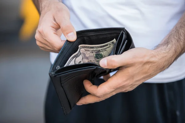 man hand money in wallet in stree