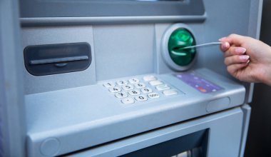 ATM / banka makinesinde kadın eli giriş kartı