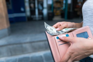 Para ve cüzdan taşıyan bir kadın.