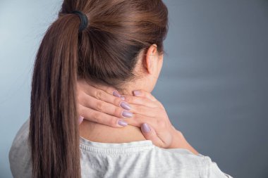 Genç bir kadın ağrı kesicisine dokunuyor.