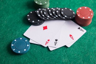 Poker masasında poker fişleri olan iki as.