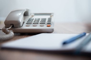 Defteri ve kalemi olan bir telefon.