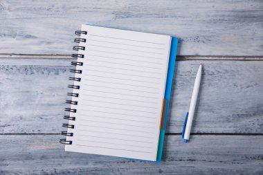 Tahta masadaki defter ve kalemi aç