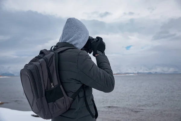 man holding camera in lake backgroun